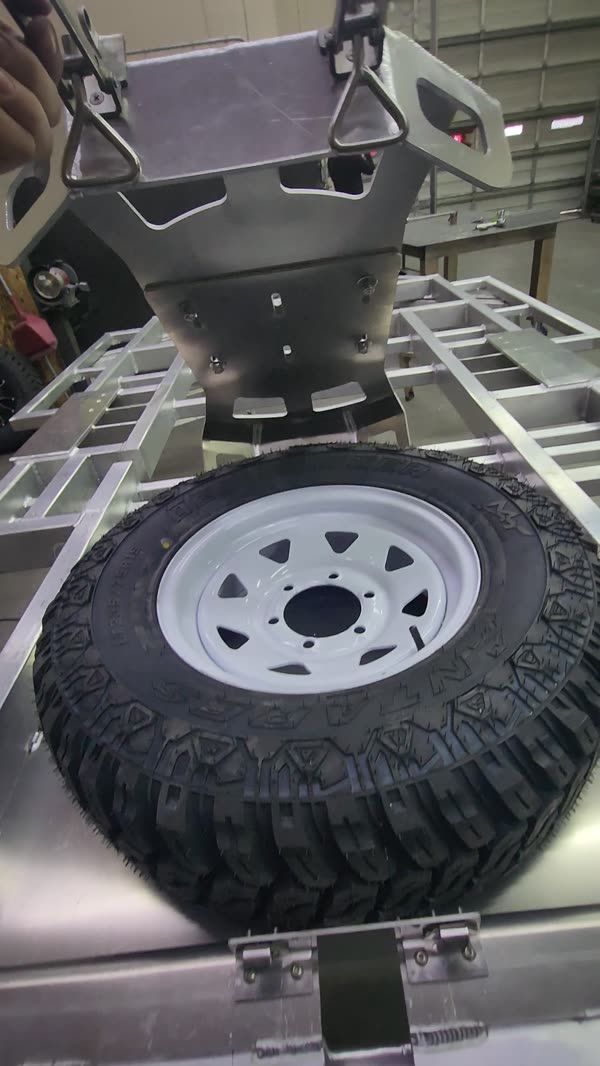 Spare tire carrier mounted on the trailer rack