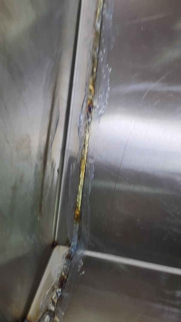 Brushing along a TIG weld seam on stainless sheet
