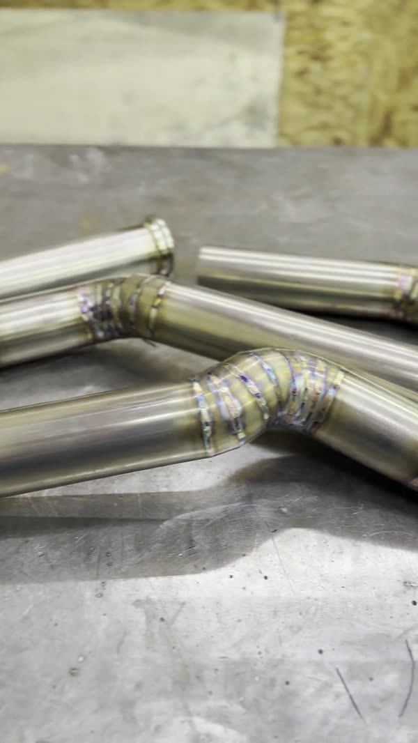 TIG-welded stainless exhaust pipes laid out on the bench